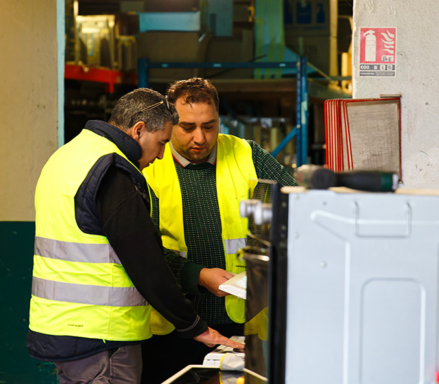 2 réparateurs réalisant un diagnostic sur un appareil électroménager au sein de l'atelier de réparation Envie Strasbourg